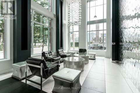 A modern living room with black and white furniture and large windows.