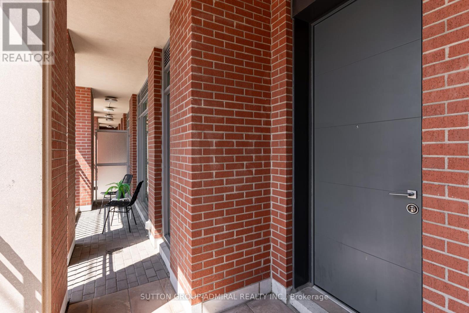 A hallway with a black door and a table with chairs.