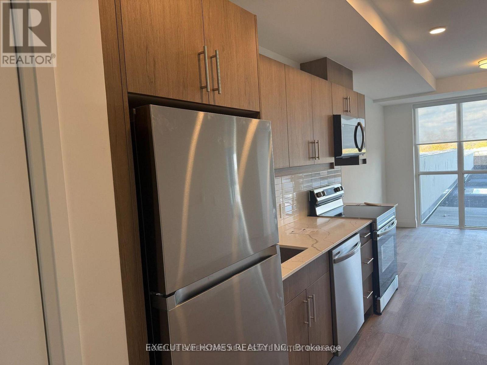 A modern kitchen with stainless steel appliances and wooden cabinets.