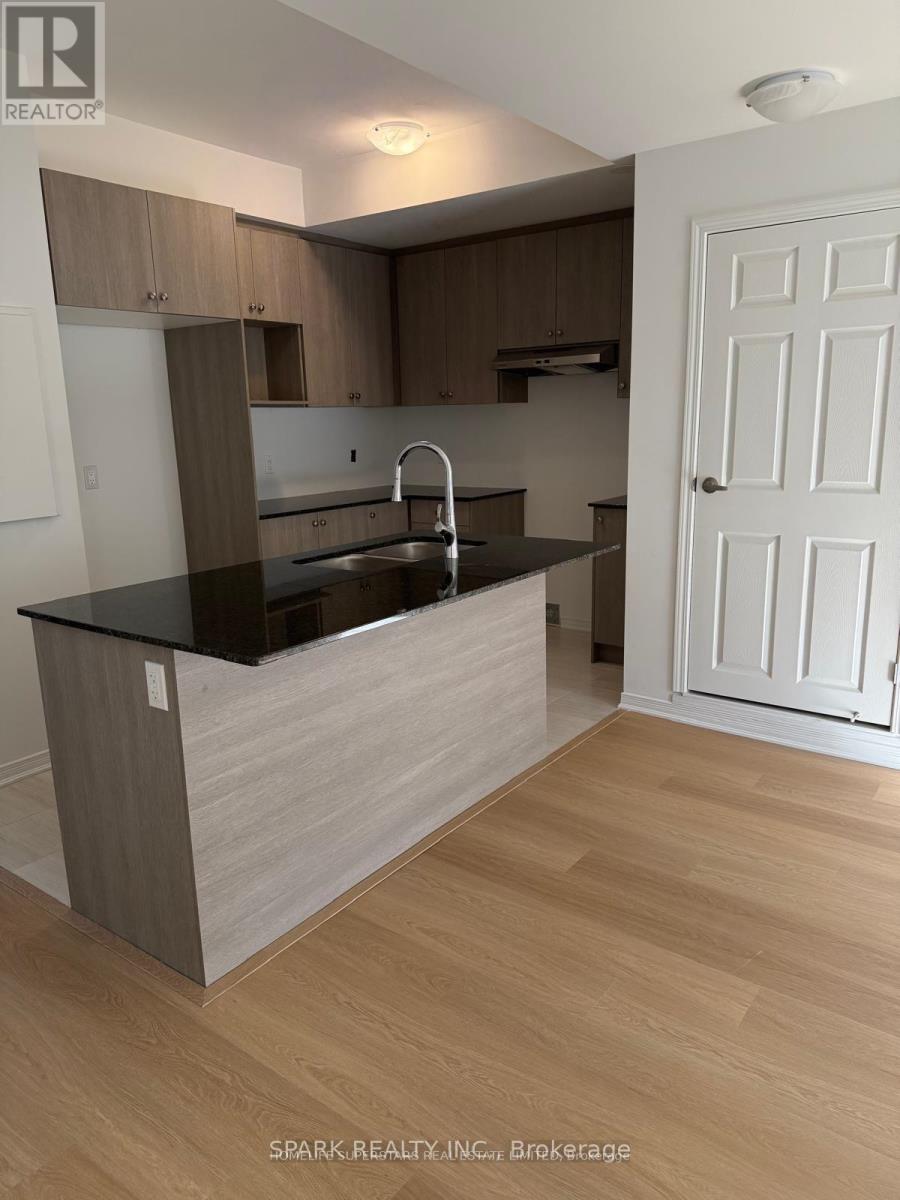 A kitchen with a black countertop and wooden cabinets.