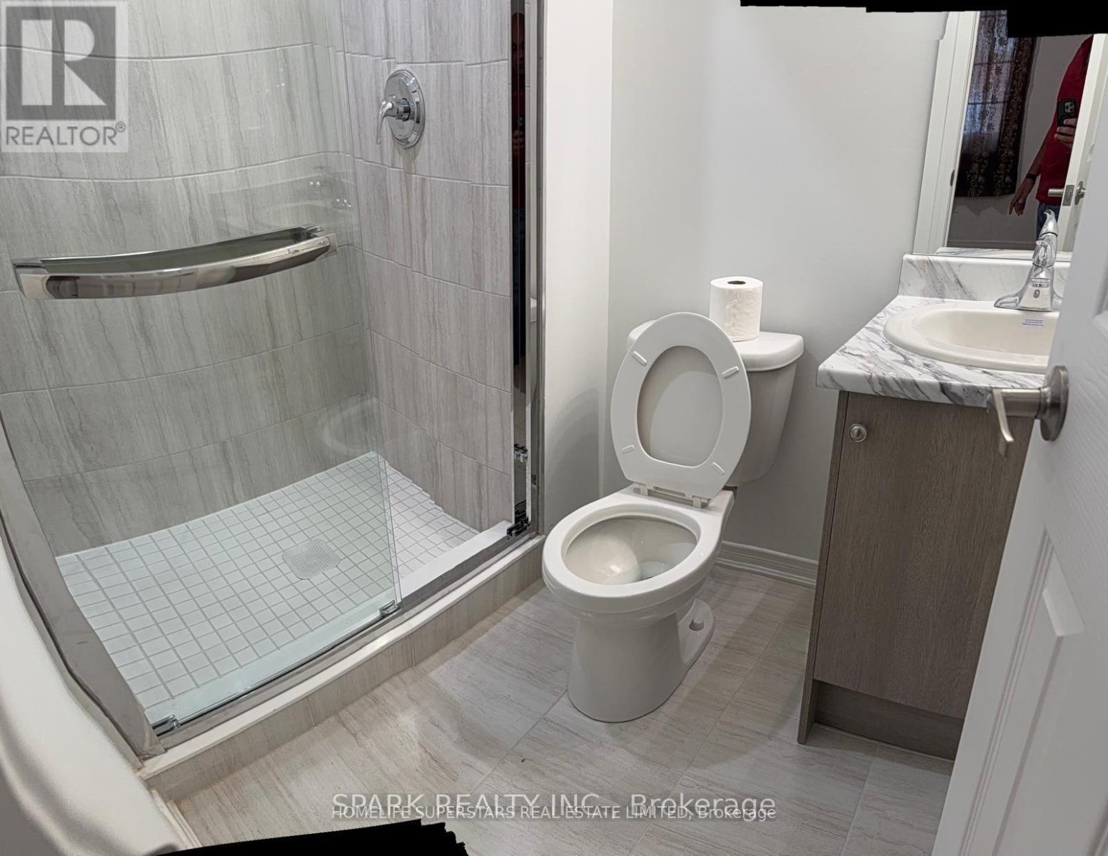 A white toilet in a bathroom with a glass shower door.
