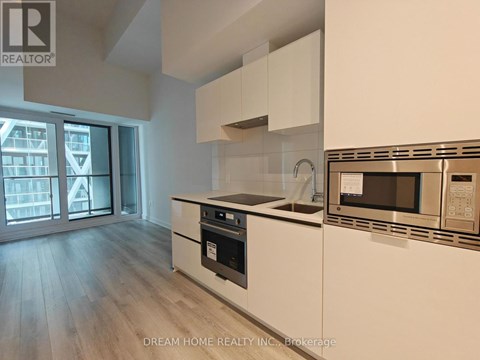 A modern kitchen with white cabinets and stainless steel appliances.