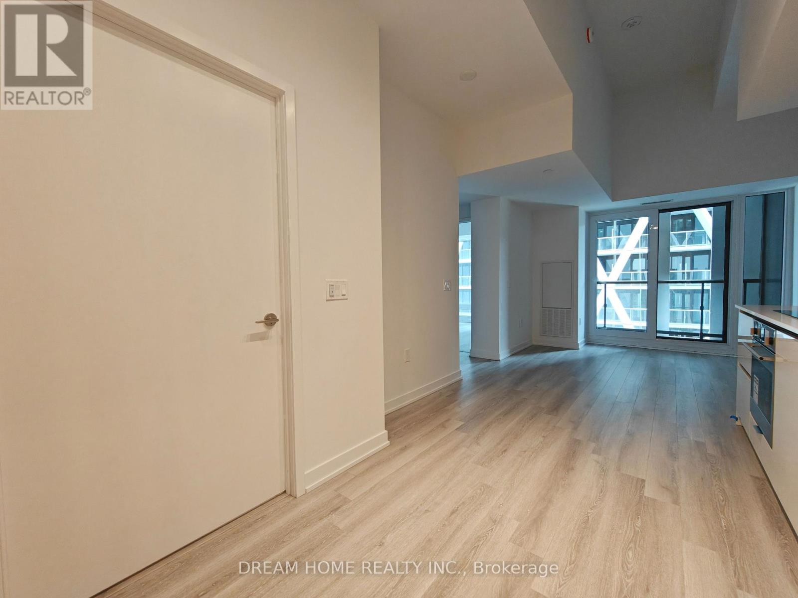 A room with a white door and wooden flooring.