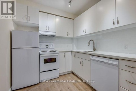 A kitchen with white appliances and cabinets.