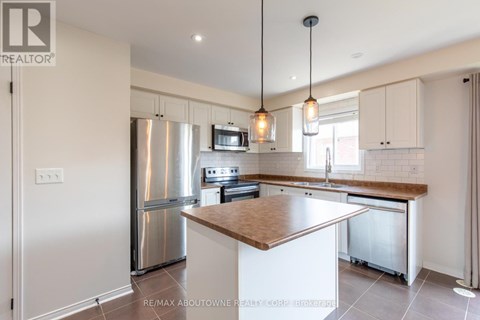 A modern kitchen with a stainless steel refrigerator and a wooden island.