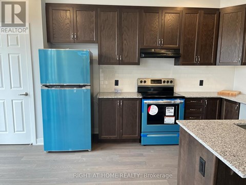 A blue fridge and stove in a kitchen with wooden cabinets.