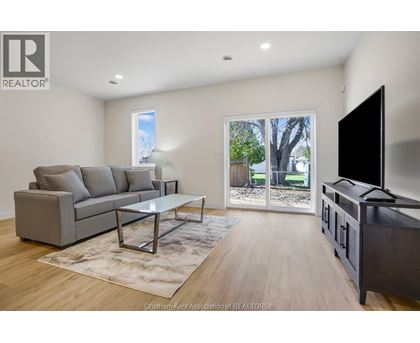 A living room with a grey couch, a coffee table, and a flat screen TV.