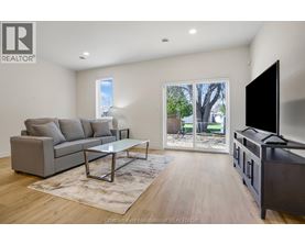 A living room with a grey couch, a coffee table, and a flat screen TV.