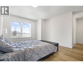 A bedroom with a large bed and a window overlooking a field.