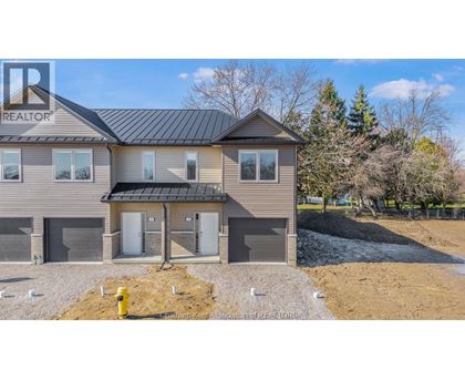 A house with a grey roof and a sign that says REALTOR on the left side.