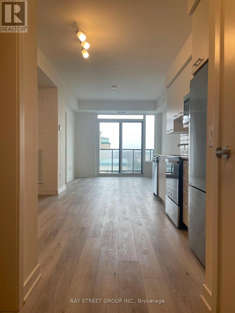 A spacious kitchen with wooden floors and stainless steel appliances.
