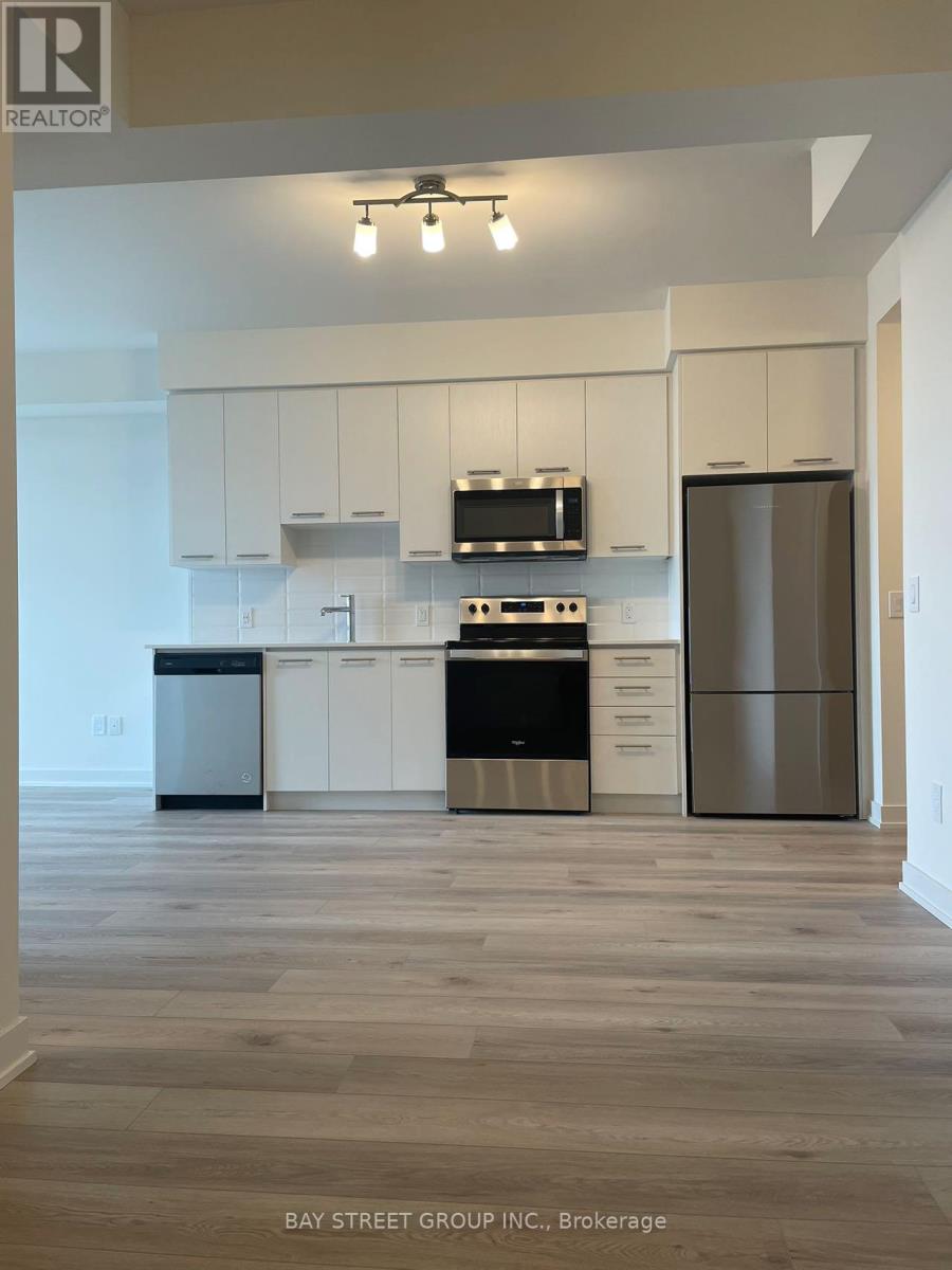 A kitchen with white cabinets and a wooden floor.