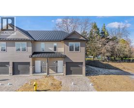 A house with a grey roof and a sign that says REALTOR on the left side.