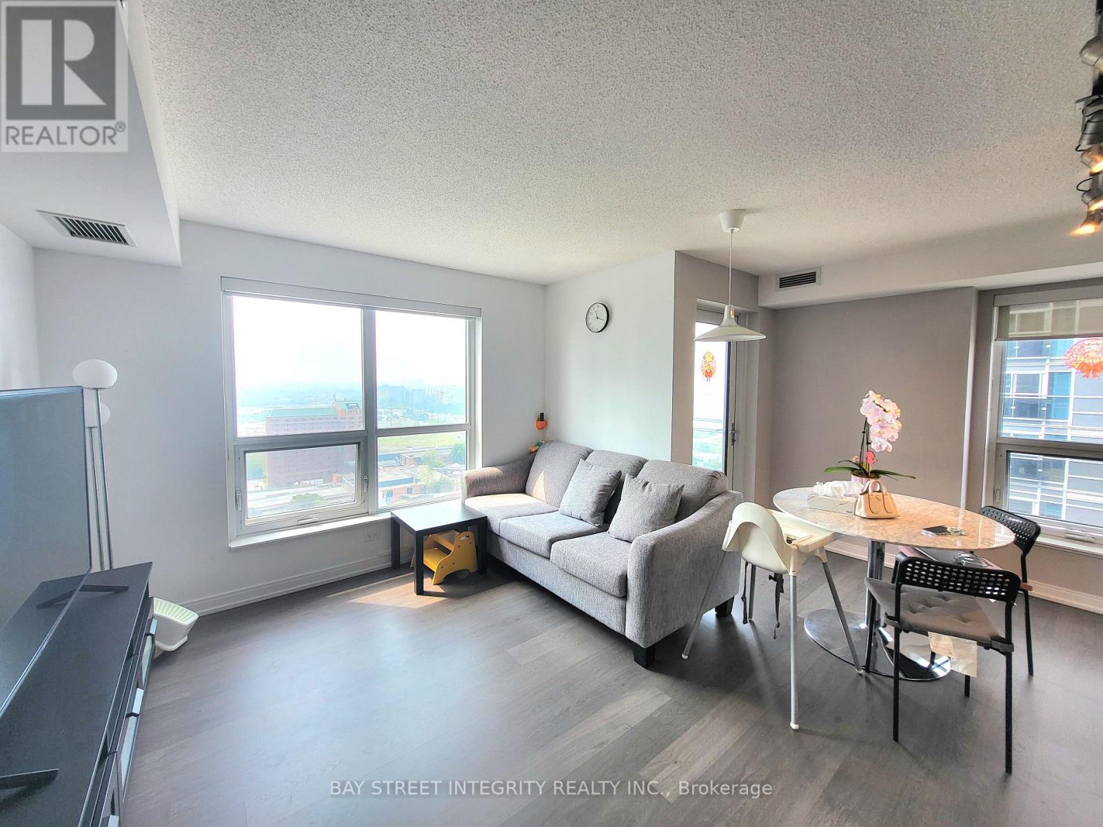 A living room with a grey couch, a white table, and a television.
