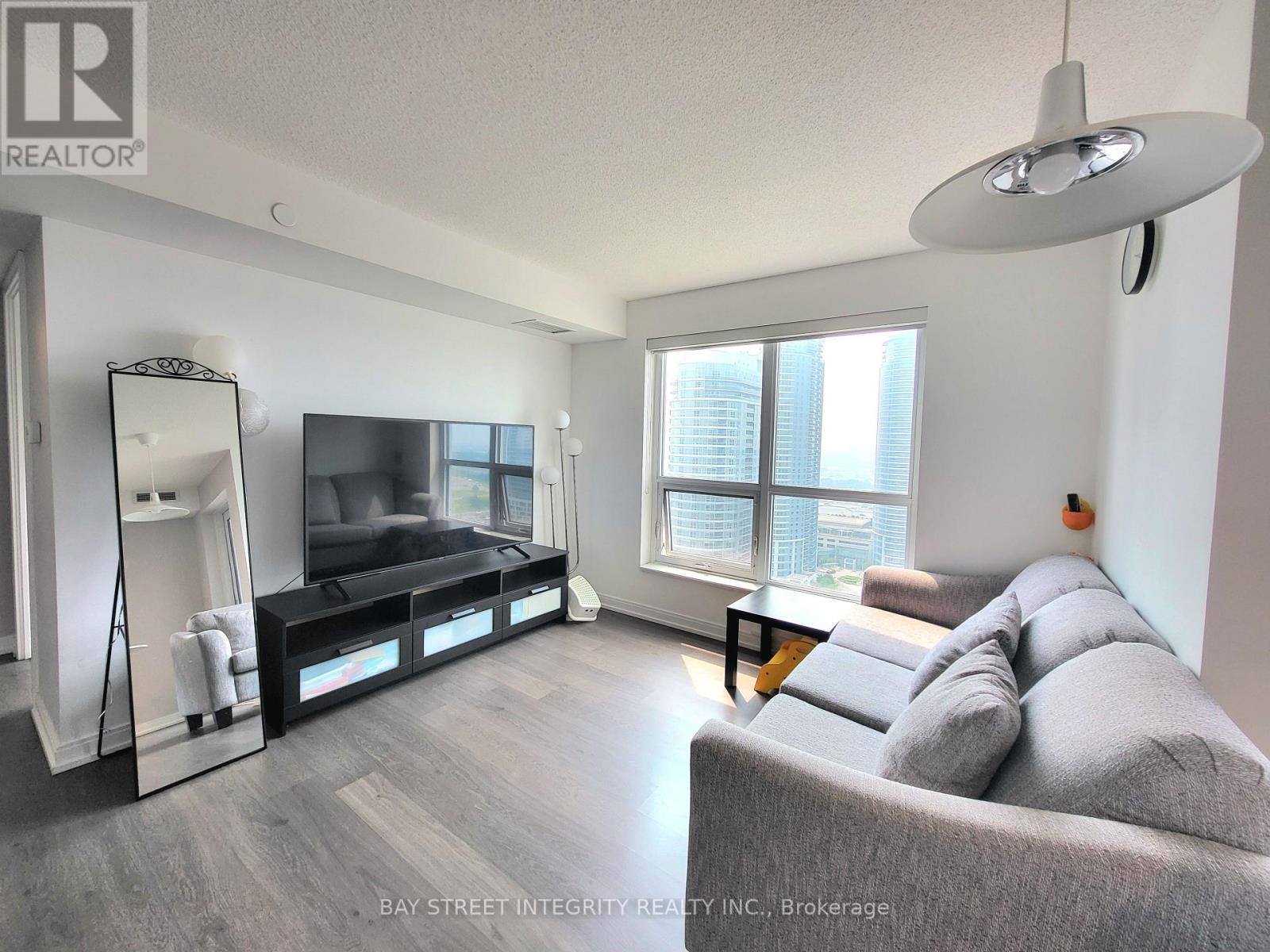 A living room with a grey couch and a flat screen TV.