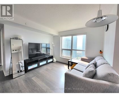 A living room with a grey couch and a flat screen TV.