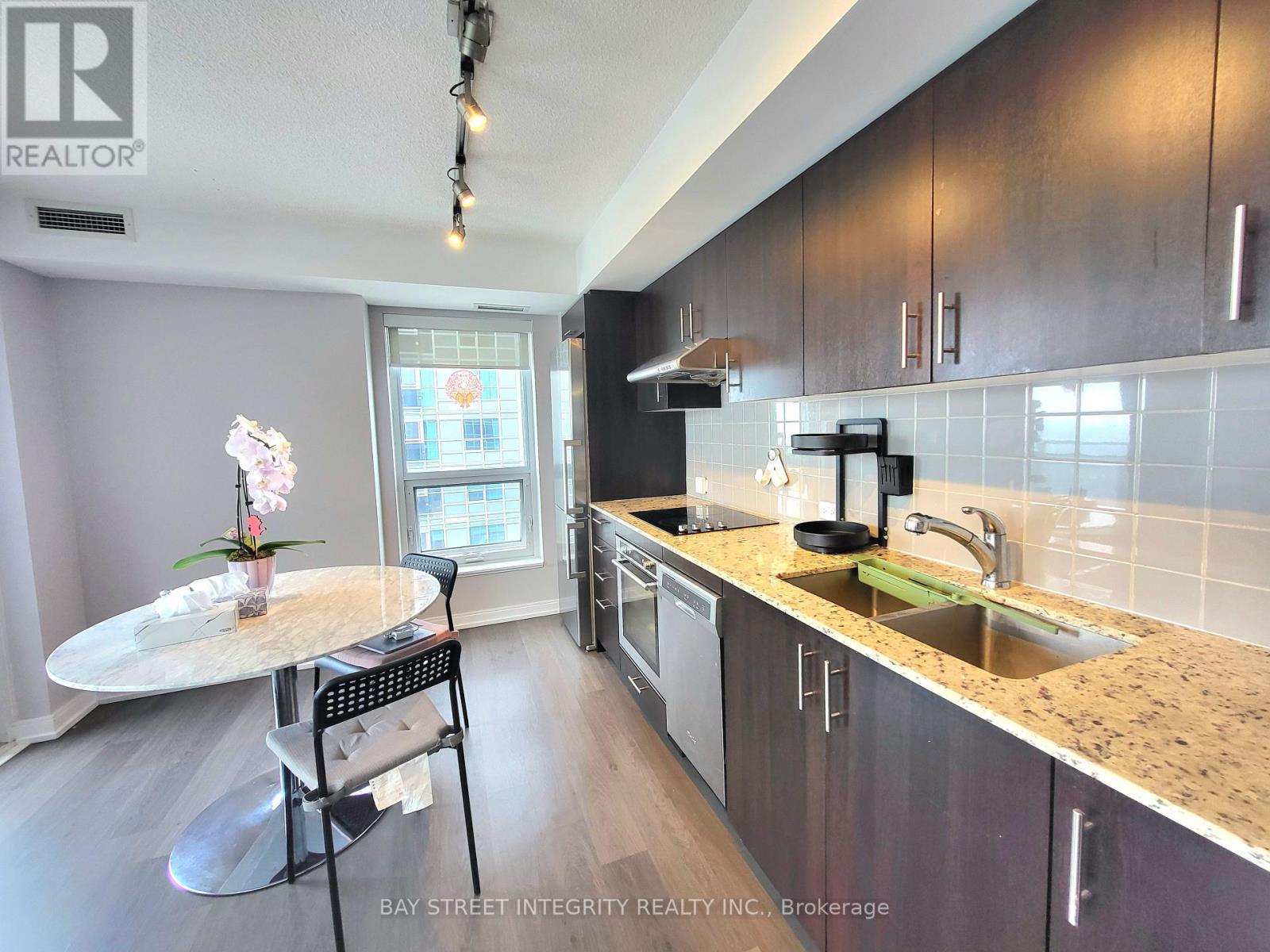 A kitchen with a table and chairs in front of a window.