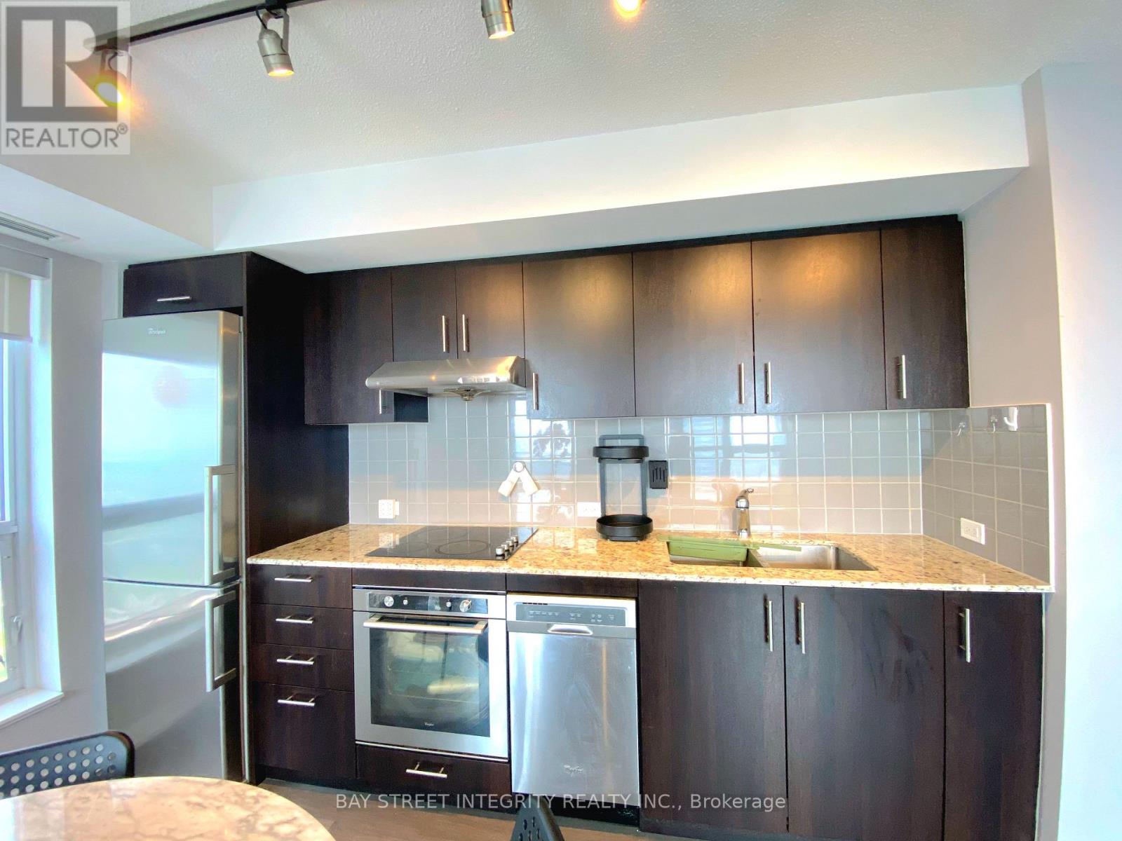 A kitchen with dark brown cabinets and stainless steel appliances.