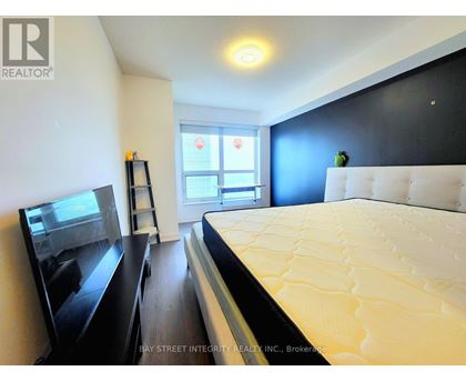 A bedroom with a large bed and a flat screen TV.