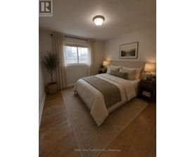 A bedroom with a large bed and a window with curtains.