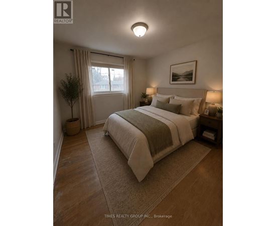 A bedroom with a large bed and a window with curtains.