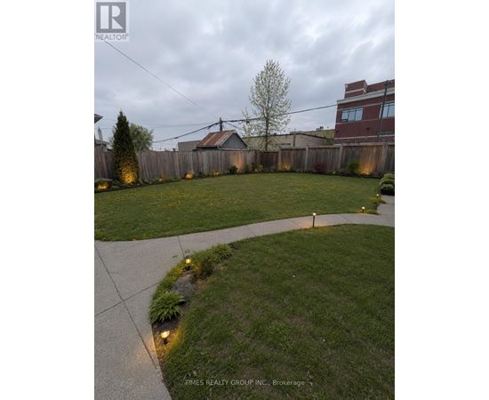 A backyard with a concrete walkway and grassy area.