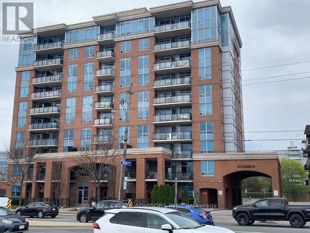 A large apartment building with a parking lot in front.