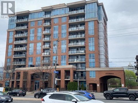 A large apartment building with a parking lot in front.