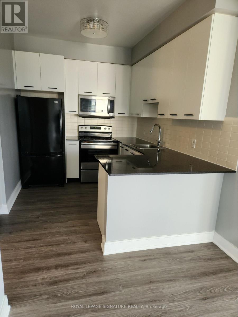 A kitchen with black appliances and white cabinets.