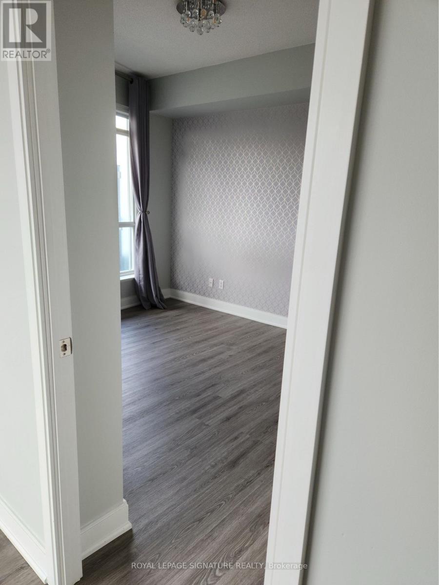 A room with a grey carpet and a chandelier.