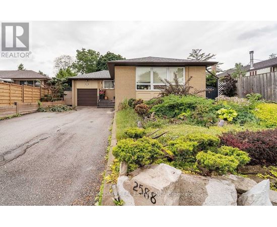 A house with a driveway and a garden in front.