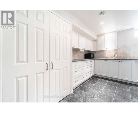 A kitchen with white cabinets and a microwave built into the counter.