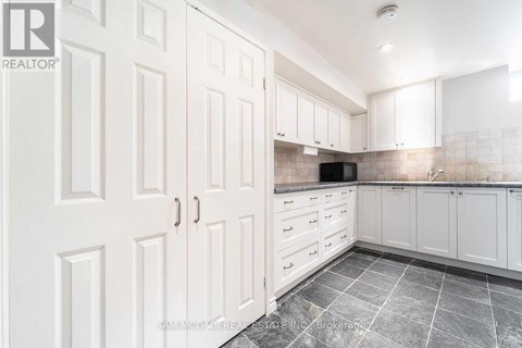 A kitchen with white cabinets and a microwave built into the counter.