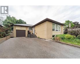 A house with a brown roof and a driveway in front of it.