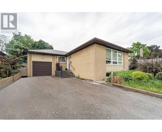A house with a brown roof and a driveway in front of it.