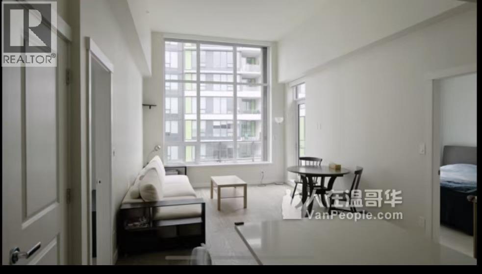 A living room with a couch, a table, and a window.