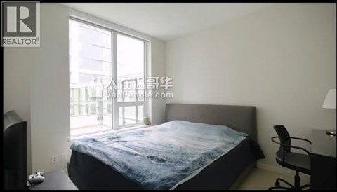 A bedroom with a large bed and a chair.