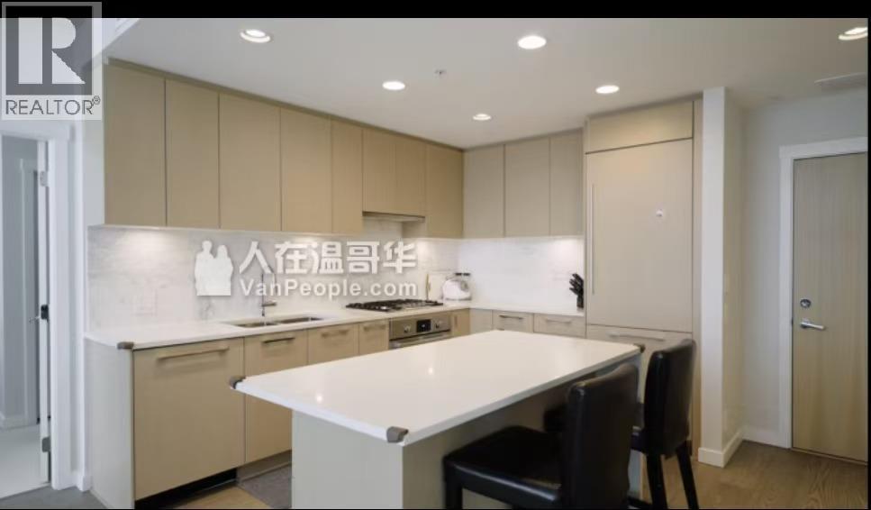 A modern kitchen with a large island and a dining table.