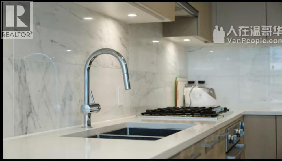 A kitchen with a marble backsplash and a stainless steel gas stove.