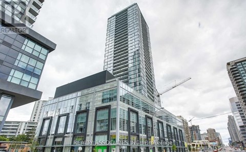 A modern glass building with a crane in the background.