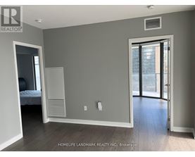 A bedroom with a bed, a closet, and a door leading to a balcony.