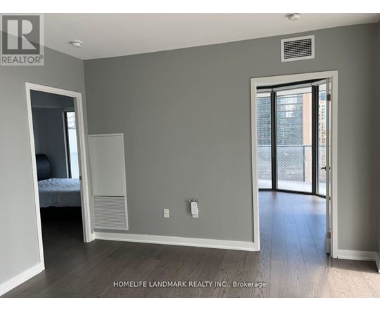 A bedroom with a bed, a closet, and a door leading to a balcony.