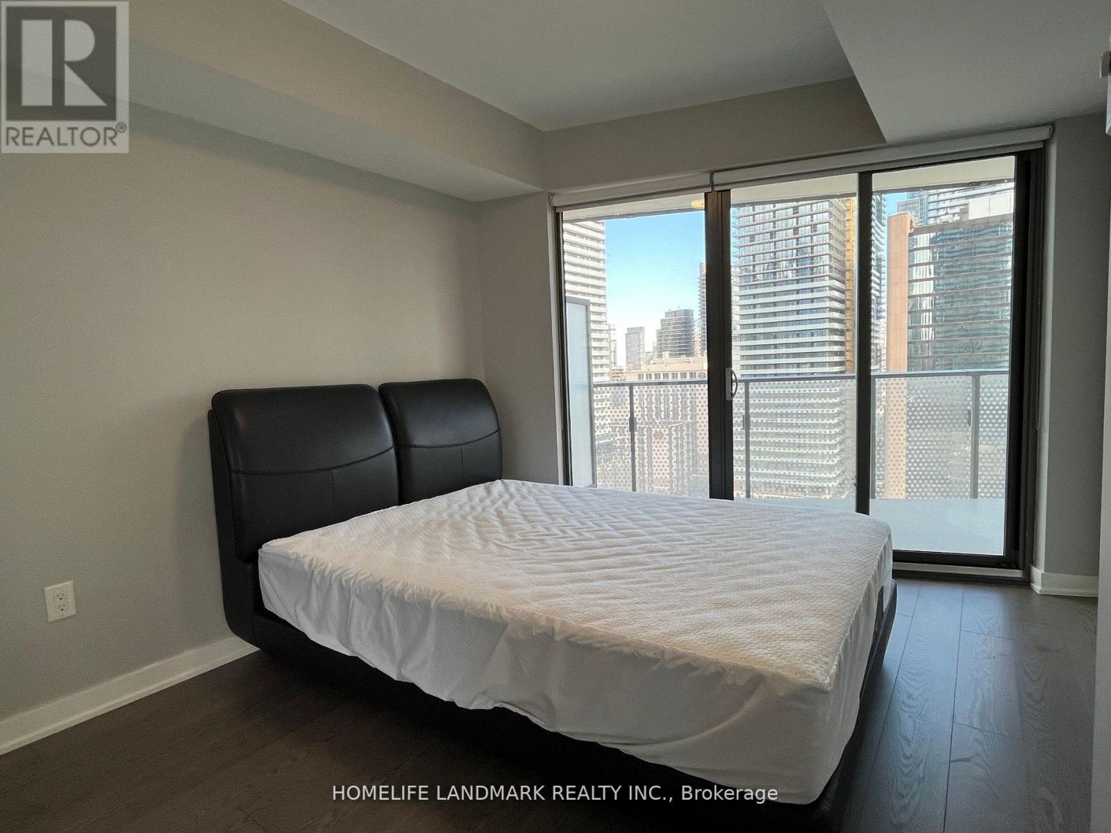 A bedroom with a large bed and a view of the city.