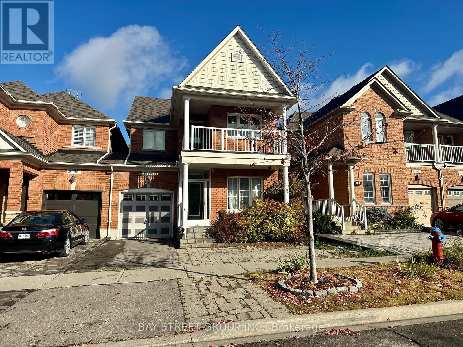 A real estate photo of a house with a car parked in front.