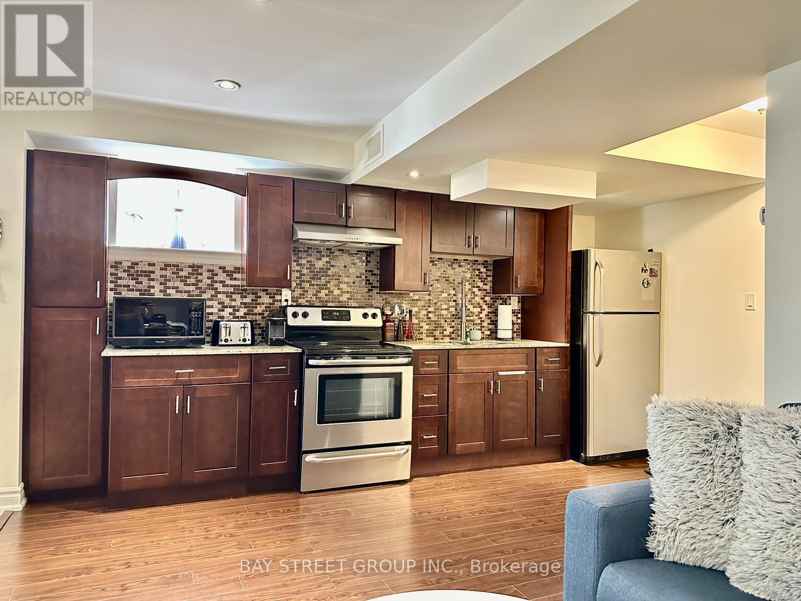 A kitchen with wooden cabinets and a stone backsplash.