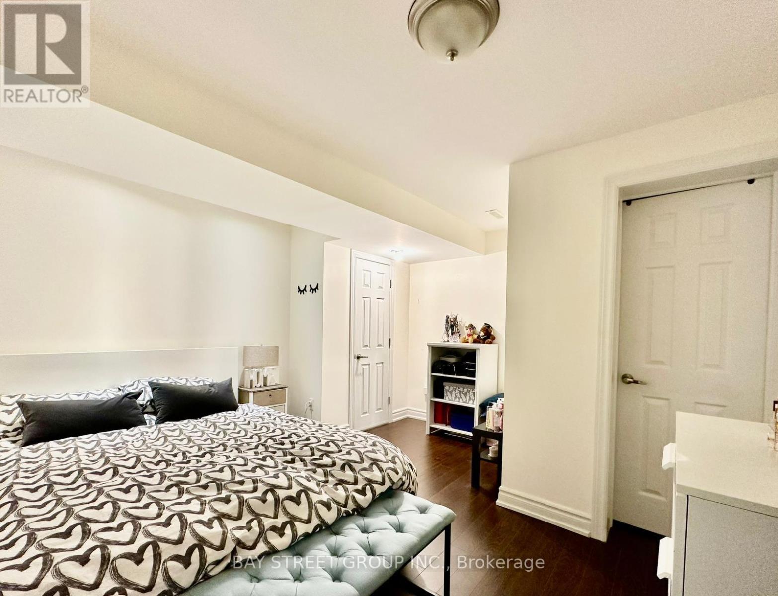 A bedroom with a bed, nightstand, and a dresser.