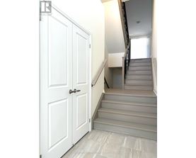 A white door is on the left and a staircase is on the right.