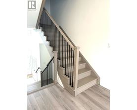 A staircase with a wooden handrail and white steps.