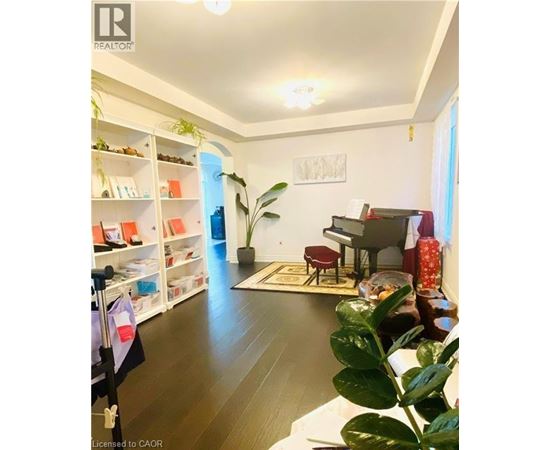 A living room with a piano and a potted plant.