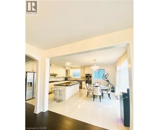 A modern kitchen with white cabinets and black countertops.